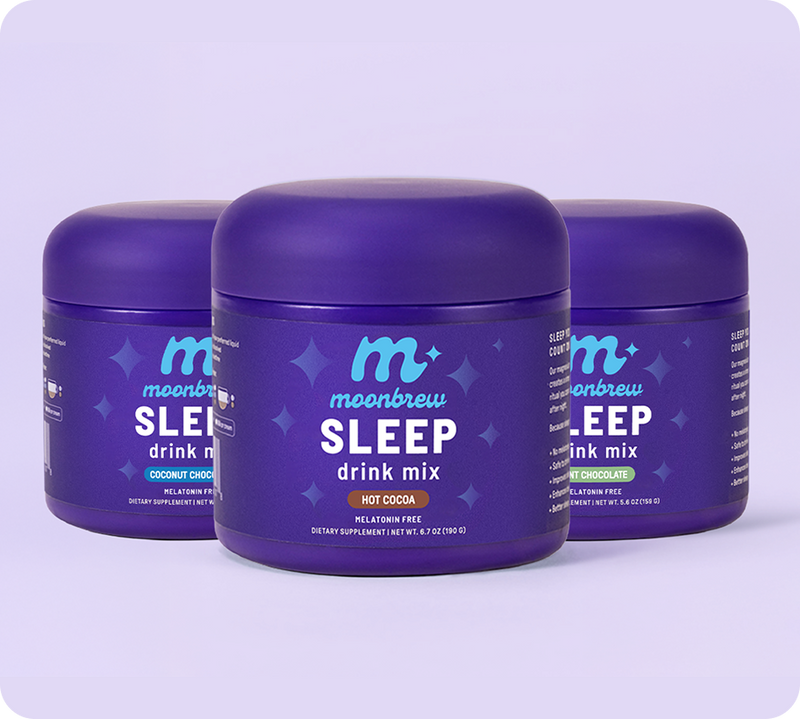 Three-quarter front view of three MoonBrew Sleep drink mix tubs, center jar labeled Hot Cocoa, on a pale lavender background