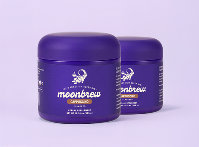 Front-left view of two MoonBrew Cappuccino magnesium sleep aid tubs showcasing purple packaging on a light lavender background