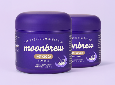 Three-quarter view of two MoonBrew Homestyle Hot Cocoa jars with purple packaging and magnesium sleep aid label on purple background