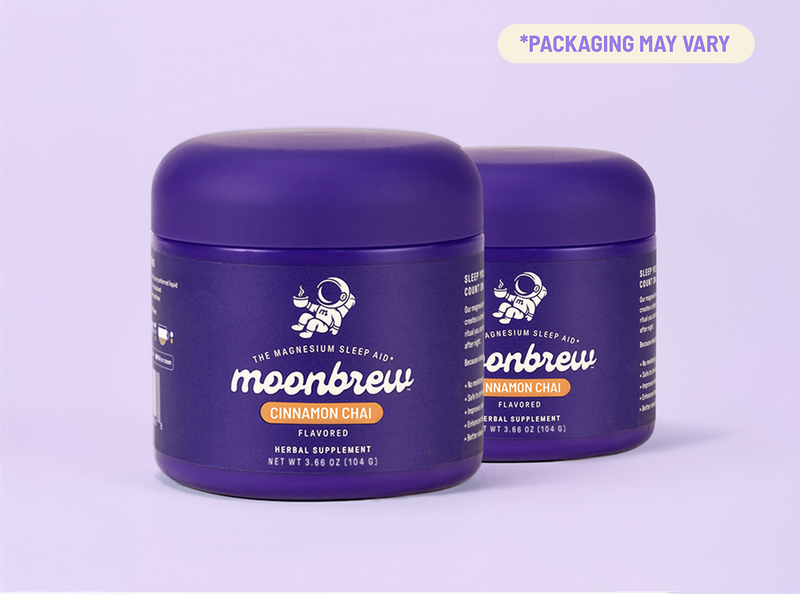 Three-quarter front view of two MoonBrew Cinnamon Chai supplement tubs showing purple packaging and label on a lavender background