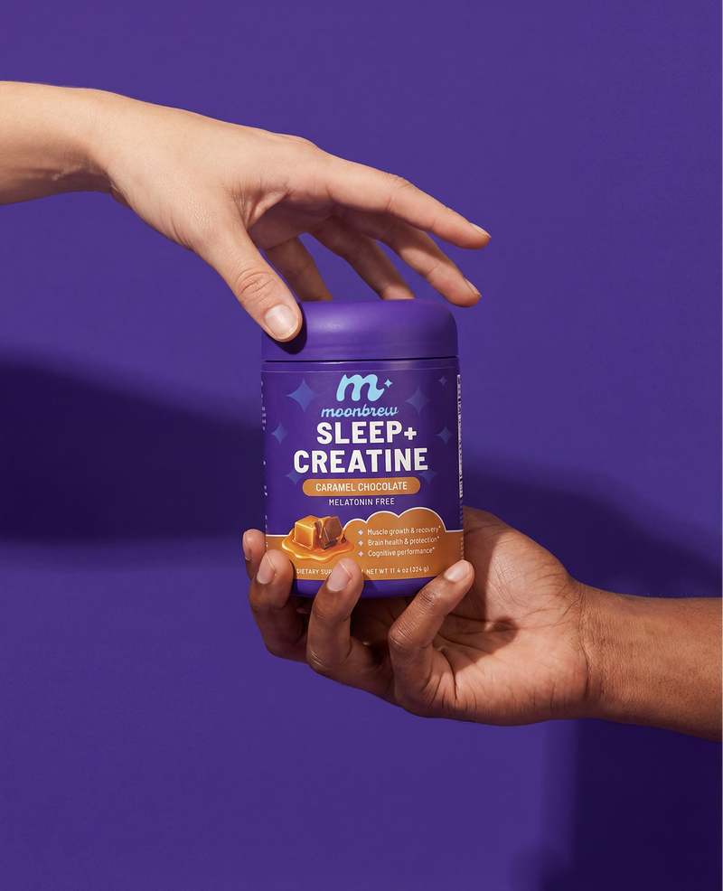 Front view of MoonBrew Sleep plus Creatine jar (Caramel Chocolate, melatonin free) held by two hands against purple background