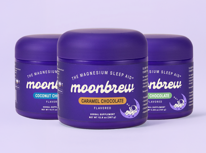Front view of three Moonbrew sleep-aid tubs, Caramel Chocolate front with Coconut and Mint behind on pale purple background