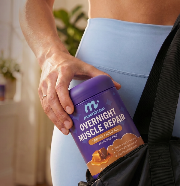 Close-up of a hand placing a tub of Overnight Muscle Repair (caramel chocolate) into a gym bag, front label and brand visible
