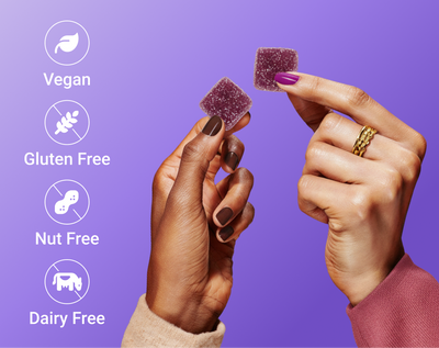 Hands holding purple Sleep + Vitamin gummies showing icons Vegan, Gluten Free, Nut Free, Dairy Free