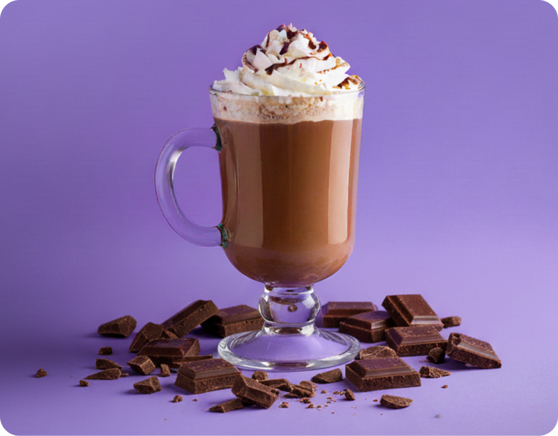 Front view of chocolate MoonBrew drink in a glass with whipped cream and chocolate pieces on a purple background