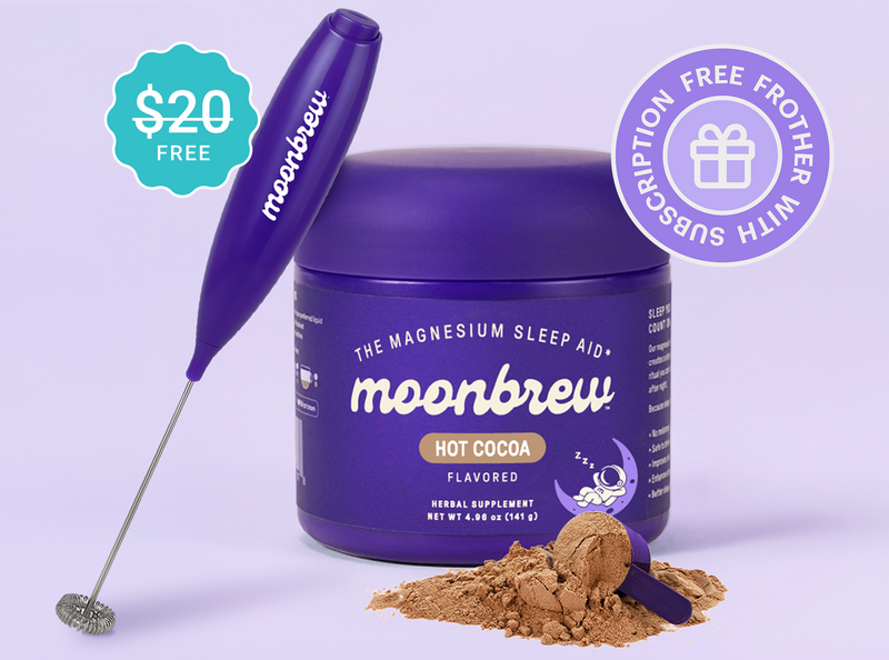 Front view of MoonBrew Homestyle Hot Cocoa jar showcasing included purple frother and a scoop of cocoa powder on a lavender background
